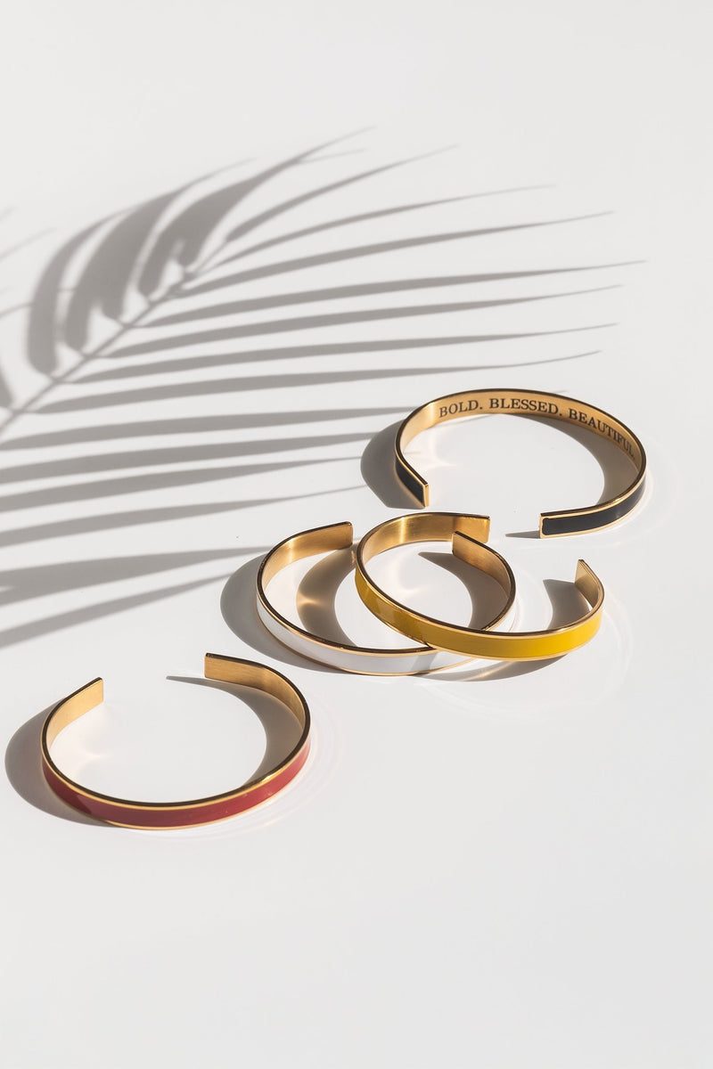 Flat lay of the Bold Blessed Beautiful 4-piece enamel bangle bracelet set from A Meaningful Mood, featuring gold-plated Christian statement bangles in vibrant colors with the engraved message "Bold. Blessed. Beautiful." — faith-based jewelry for women who love expressive, stylish accessories.