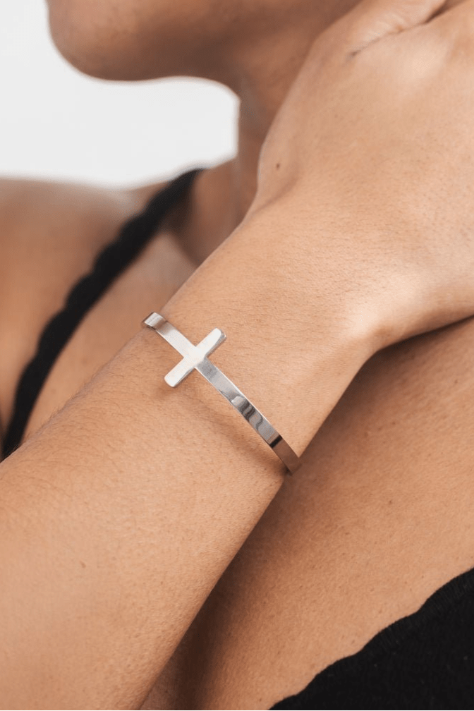 Close-up of stainless steel Christian cross bracelet on wrist, showcasing elegant faith jewelry for women.