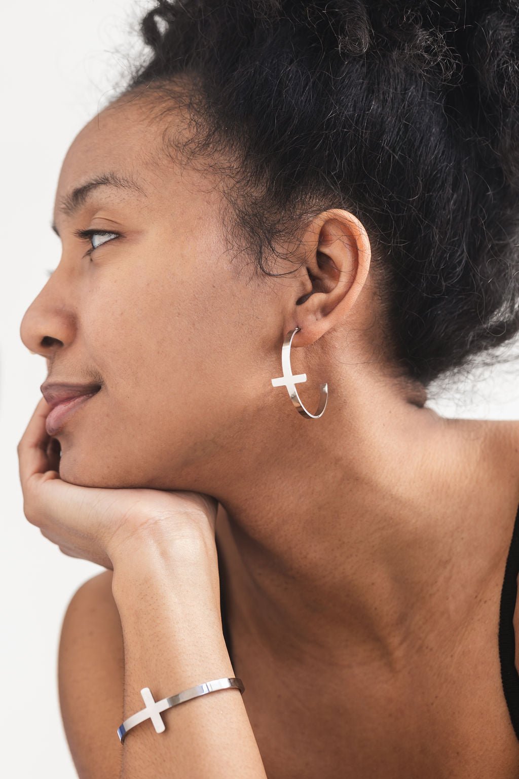 Side profile of a woman wearing stainless steel So Chic Cross Hoop Earrings and matching cross bangle from A Meaningful Mood — minimalist faith-based jewelry for Christian women who love bold, modern style.