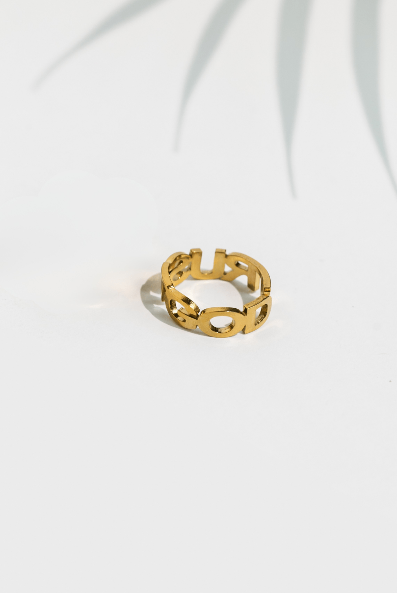 Back view of the Trust God gold ring showing smooth 18k gold-plated band and partial cutout design on a clean white surface.