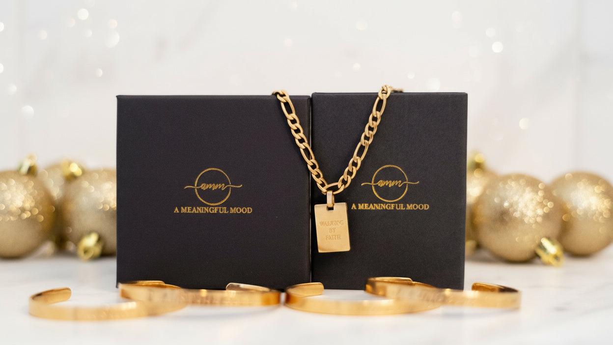 Gold necklace and bracelets on a black jewelry box with 'A Meaningful Mood' branding, surrounded by gold ornaments.
