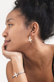 Side profile of a woman wearing stainless steel So Chic Cross Hoop Earrings and matching cross bangle from A Meaningful Mood — minimalist faith-based jewelry for Christian women who love bold, modern style.