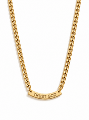 A gold chain necklace with a curved bar pendant with the words 'TRUST GOD' laser cut in capital letters, shown against a plain white background.