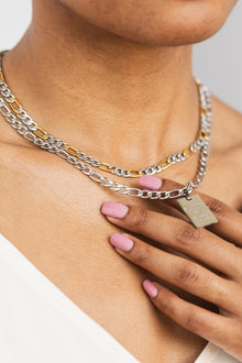 Close-up of layered two-tone stainless steel Christian necklaces with “Walking by Faith” engraved pendant — faith-based jewelry for women by A Meaningful Mood that blends modern style with spiritual inspiration.